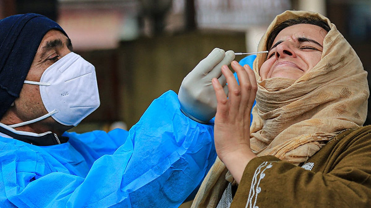 Healthcare worker takes a swab sample of a woman for the Covid-19 test.