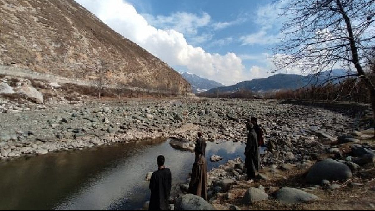 People standing along the stream.