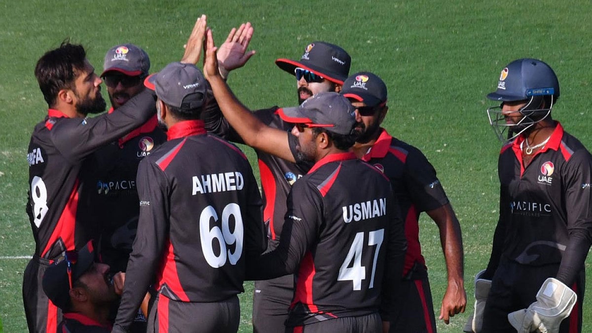 UAE cricketers celebrate the fall of an Ireland wicket.