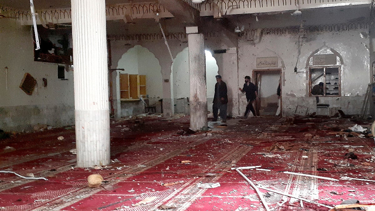 Volunteers examine the site of explosion inside a Shiite mosque in Peshawar, Pakistan.