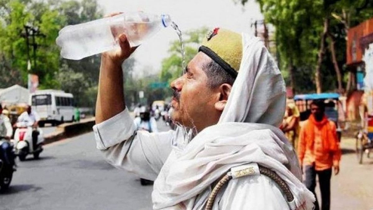 A police officer pours water over his head, as temperature in Delhi soars