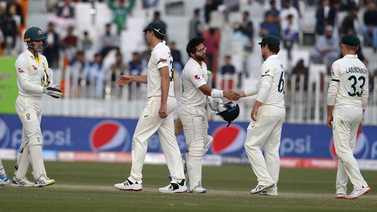 Pakistan's Imam-ul-Haq (center) shakes hand with Australian players at end of Rawalpindi Test match.