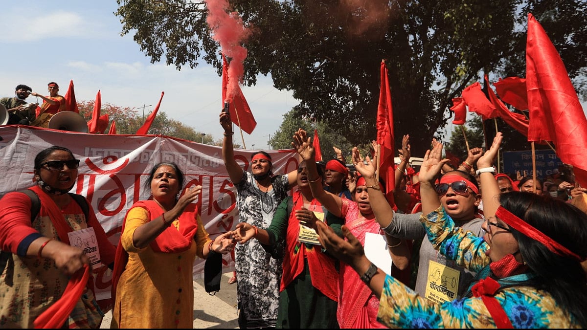 Anganwadi workers raise flags during rally at Delhi's Raj Ghat.