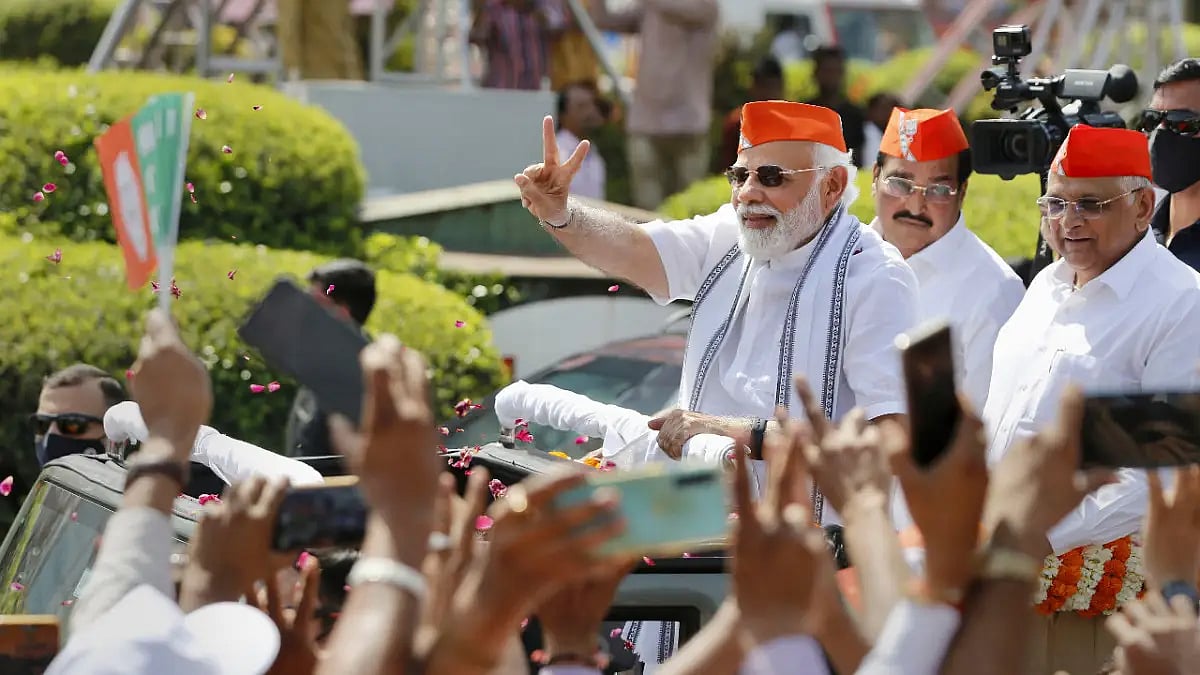 Prime Minister Narendra Modi flashes the victory sign during a roadshow after BJPs victory