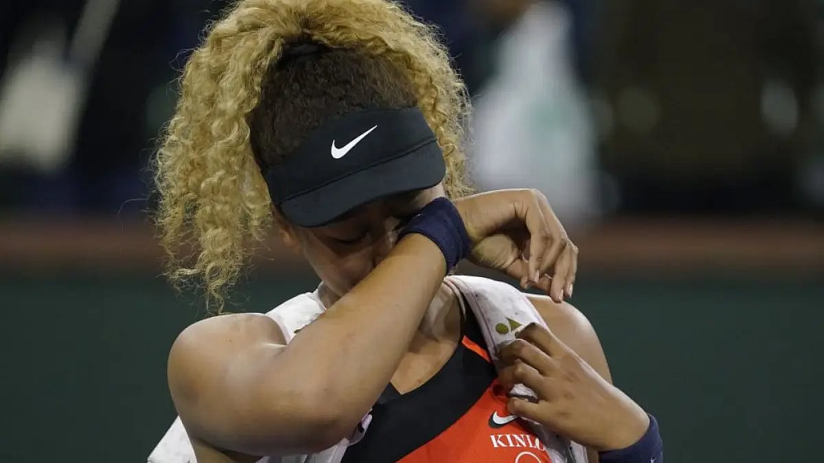 Naomi Osaka wipes away tears as she leaves court after loss to Veronika Kudermetova at Indian Wells.