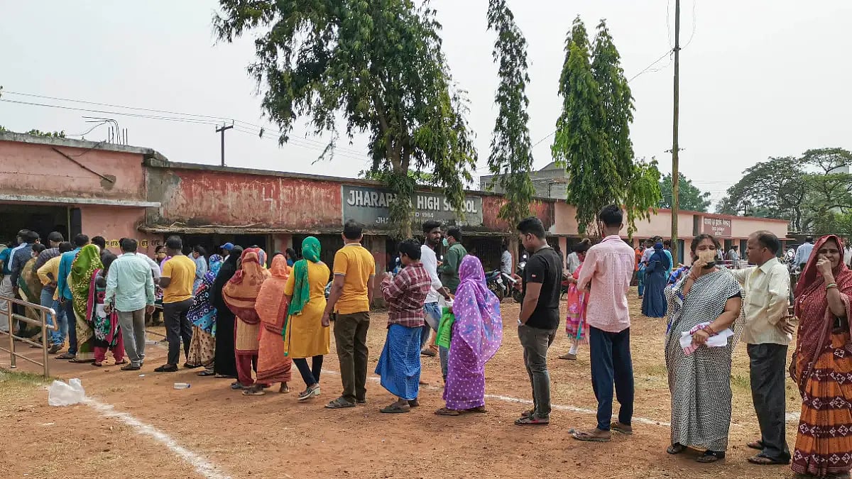 People wait in a queue to cast their votes for the Urban Local Body (ULB) polls at a polling centre
