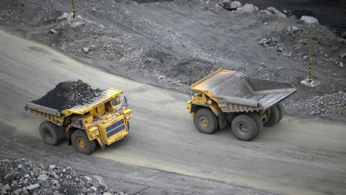  A loaded dump truck passes an empty truck as it carries away coal at mine in Russia.