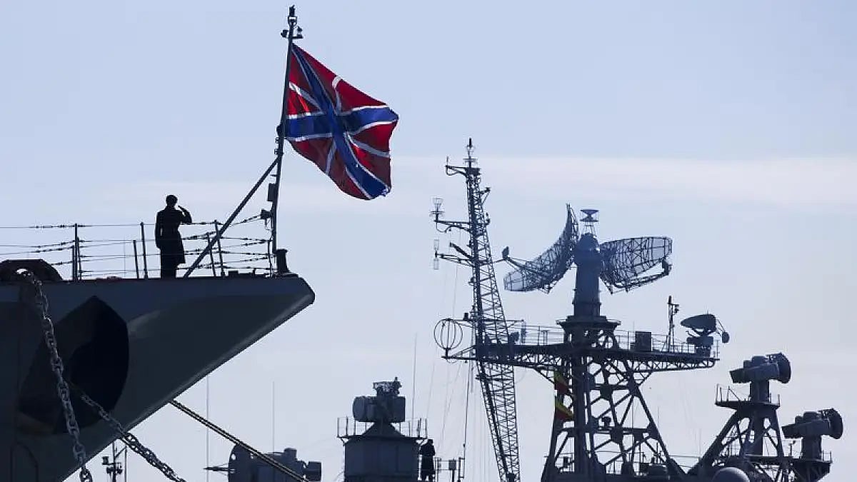 A Russian sailor salutes on the bow of Missile Cruiser Moskva