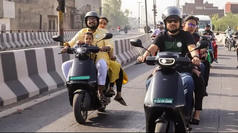 People riding Ola electric scooters - null