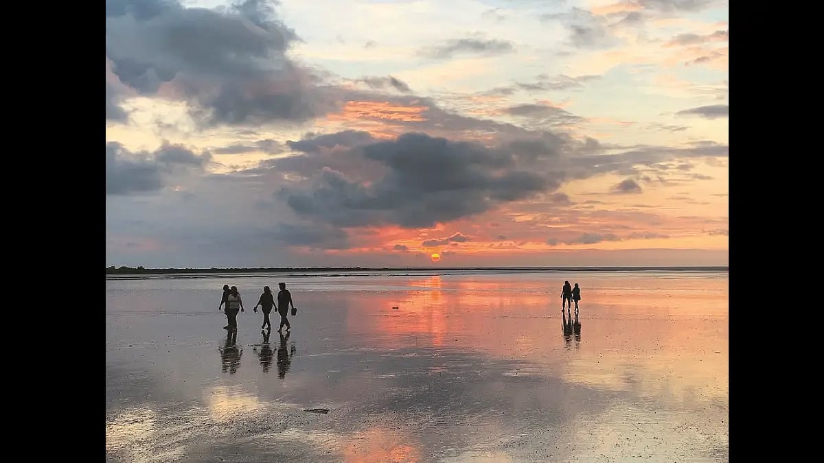 Families enjoy a low-tide sunset on Bordi beach