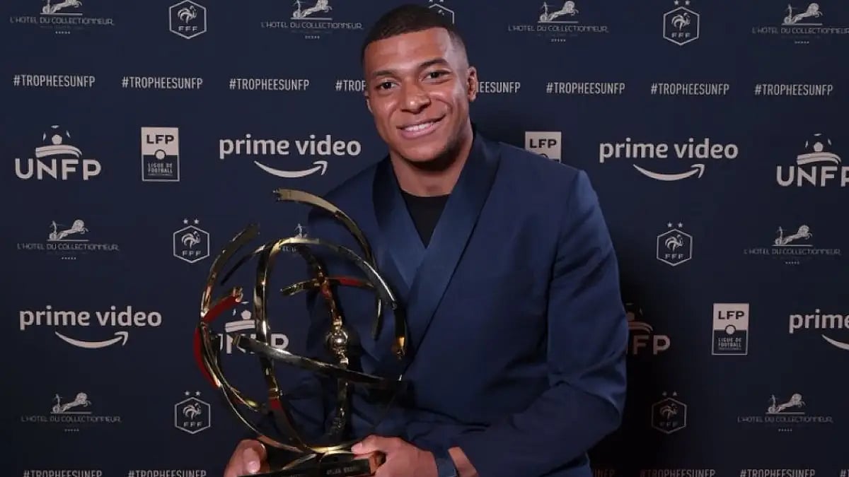 PSGs Kylian Mbappe poses with the Ligue 1s best player award in Paris on Sunday. - null