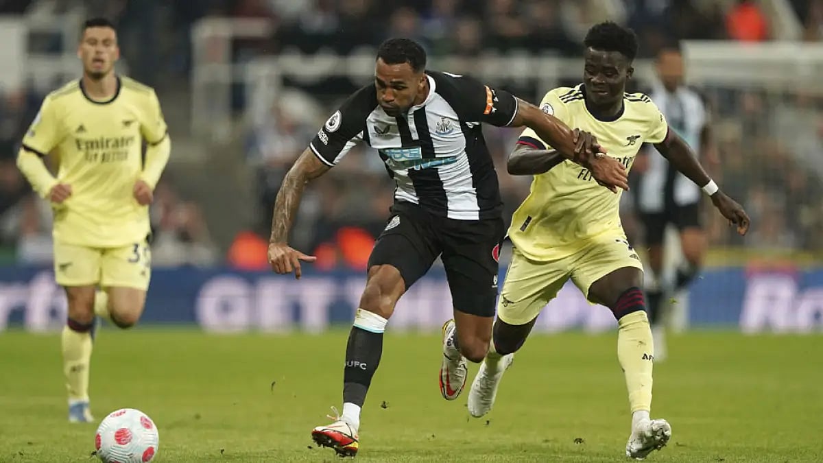 Newcastle United's Callum Wilson, left, and Arsenal's Bukayo Saka battle for the ball during their English Premier League match at St. James' Park, May 16, 2022.