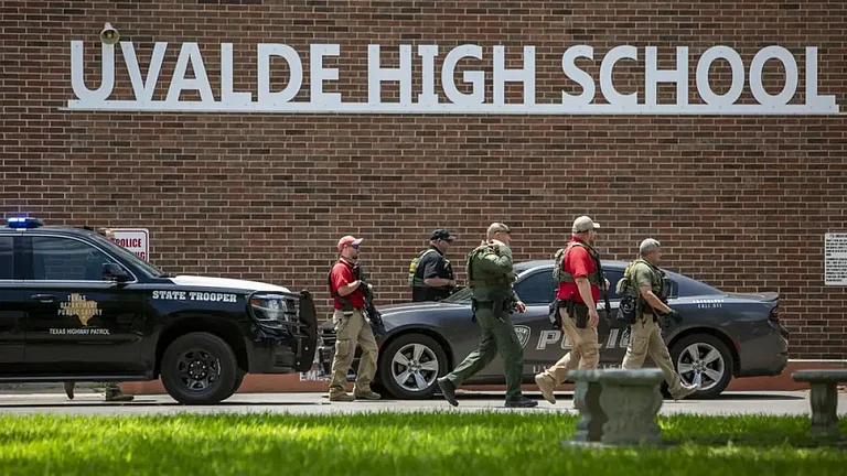 Law enforcement personnel walk outside Uvalde High School after shooting a was reported. - null
