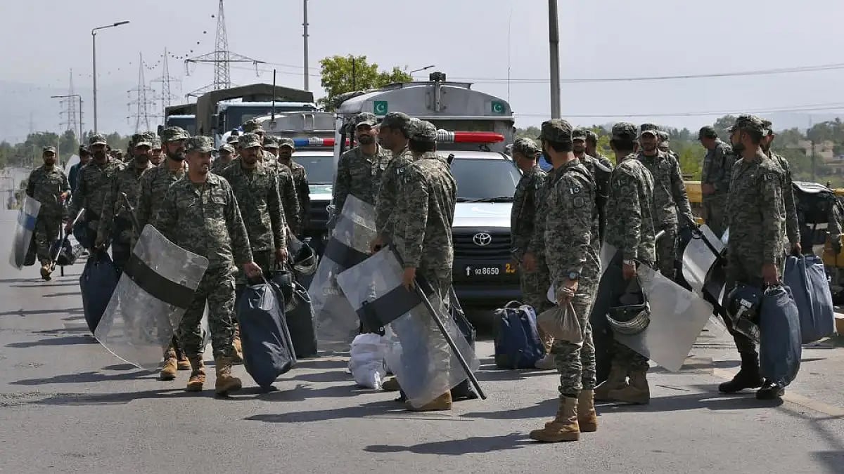Paramilitary soldiers with riot gears arrive to take position at an entry point to capital city.