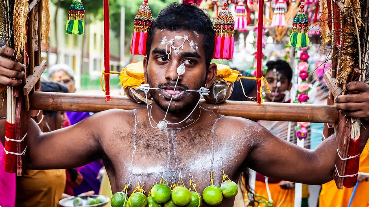 A devotee, with pierced face and body, carrying a kavadi during the Thaipusam festival 