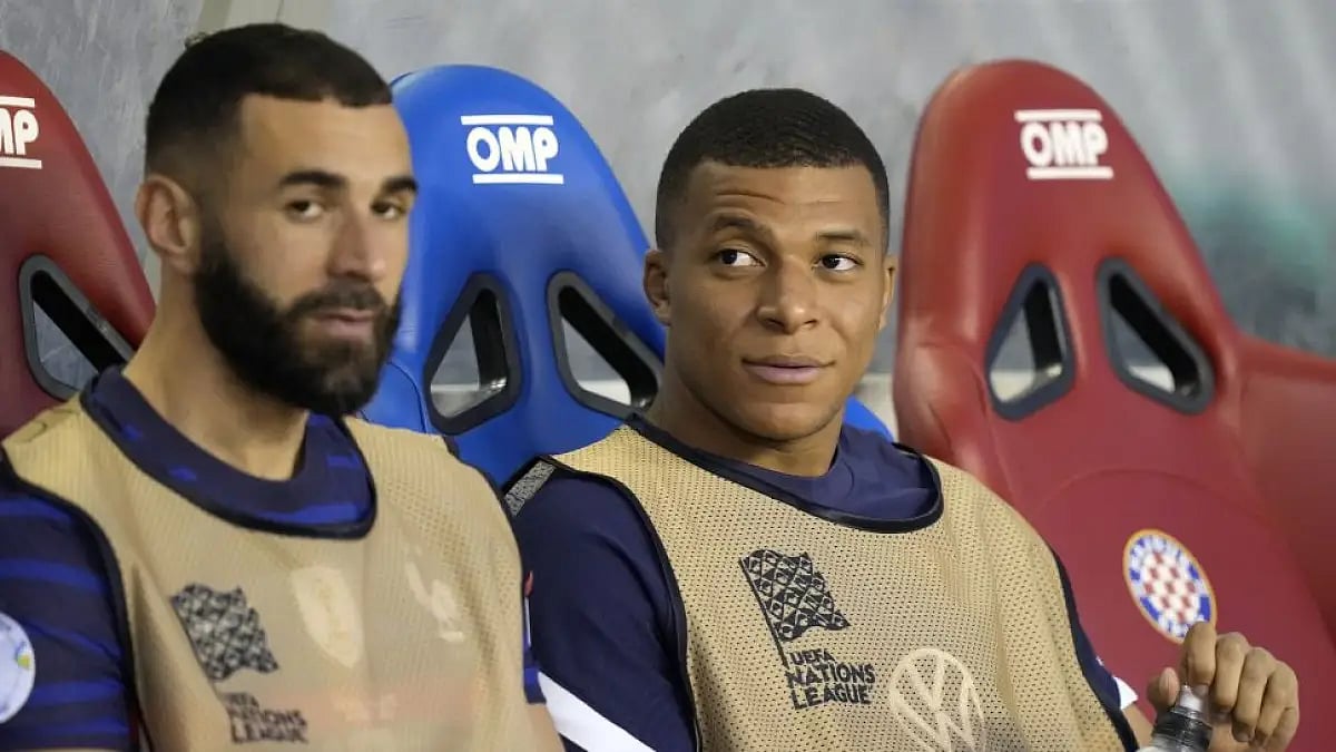 France's Kylian Mbappe (right) and teammate Karim Benzema look out from the bench before the UEFA Na