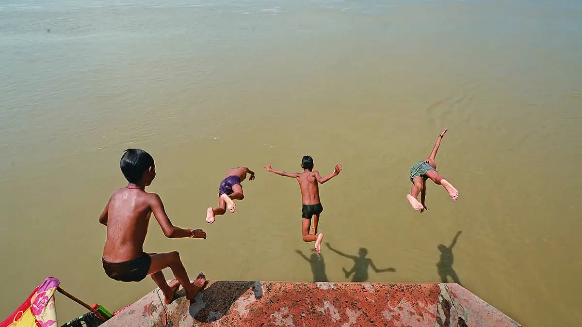 Sons of the river Boys, known as Yamunaputras, take a dive into the river at Keshi Ghat in Vrindavan