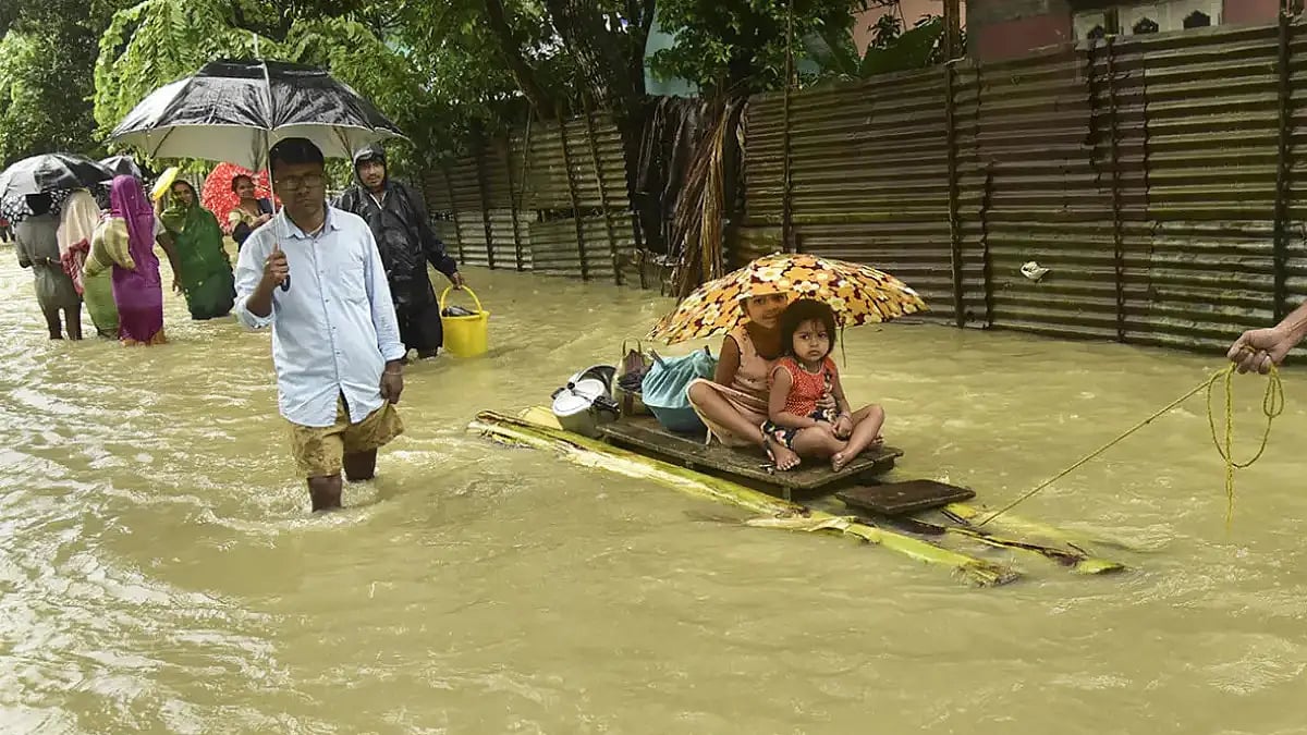 People use a banana raft to move to a safe place at a flood-hit village in Nalbari district of Assam