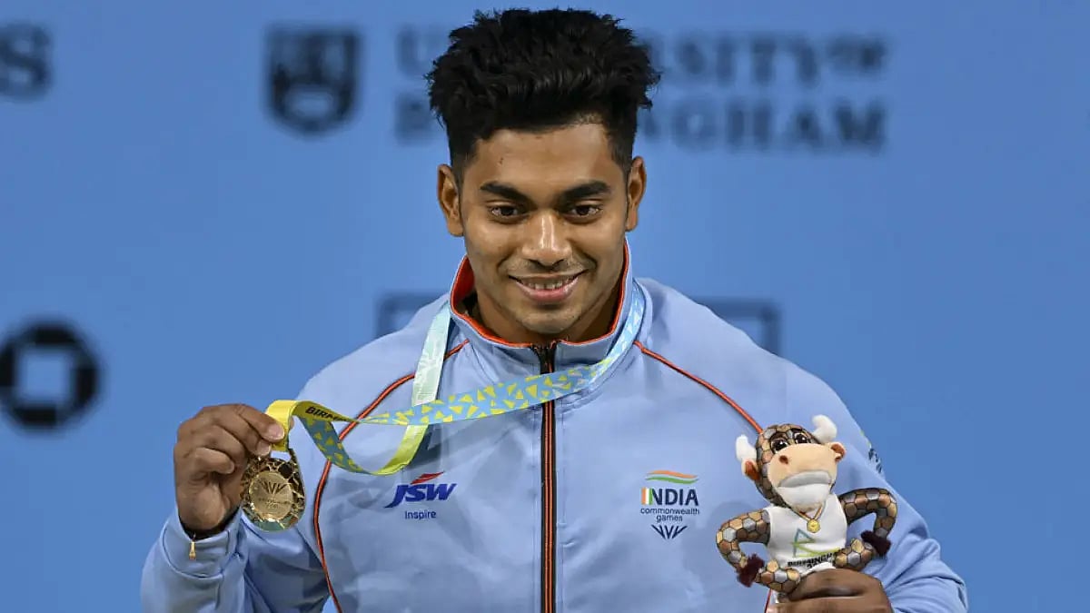 India's Achinta Sheuli with the gold medal after winning the men's 73kg weightlifting at Commonwealt