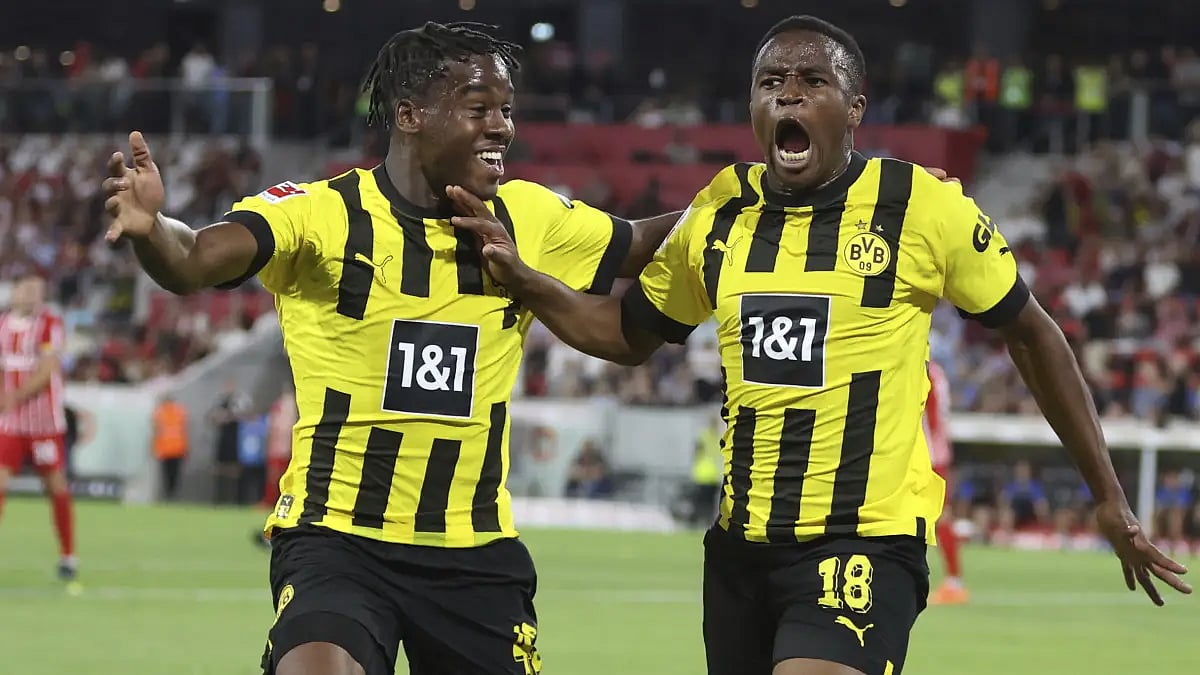 Youssoufa Moukoko celebrates with Jamie Bynoe-Gittens (L) against Freiburg in Bundesliga.