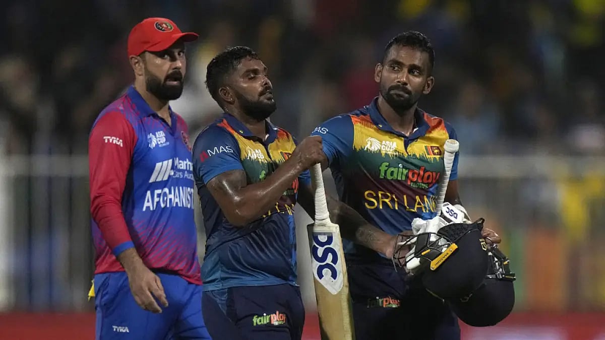 Sri Lanka's Chamika Karunaratne, right, Wanindu Hasaranga and Afghanistan's Mohammad Nabi, after the
