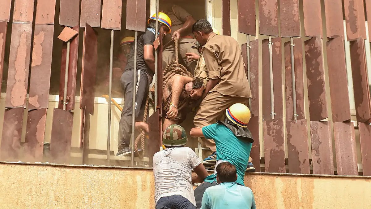 Fire Brigade personnel evacuate an injured person after fire in a hotel in Lucknow on Monday