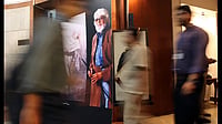 People pass by the poster of M.F. Hussain put up outside Jahangir Art Gallery during his condolence 