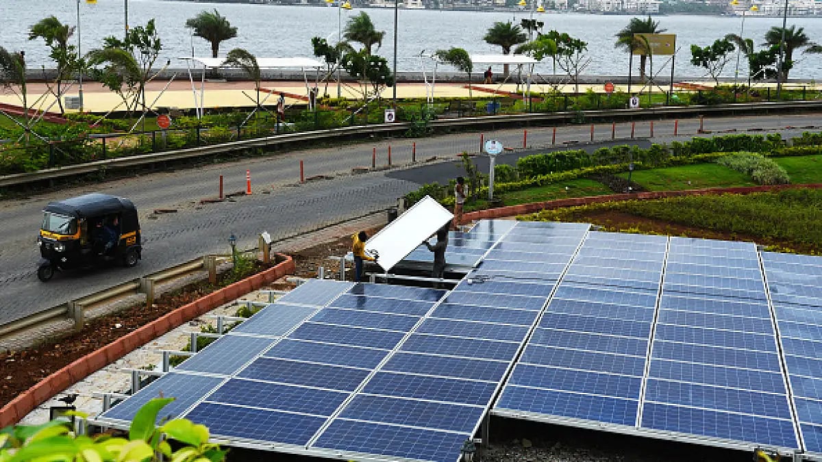 A worker installs the Solar Panels at Reclamation, Bandra, on June 18, 2019 in Mumbai, India.