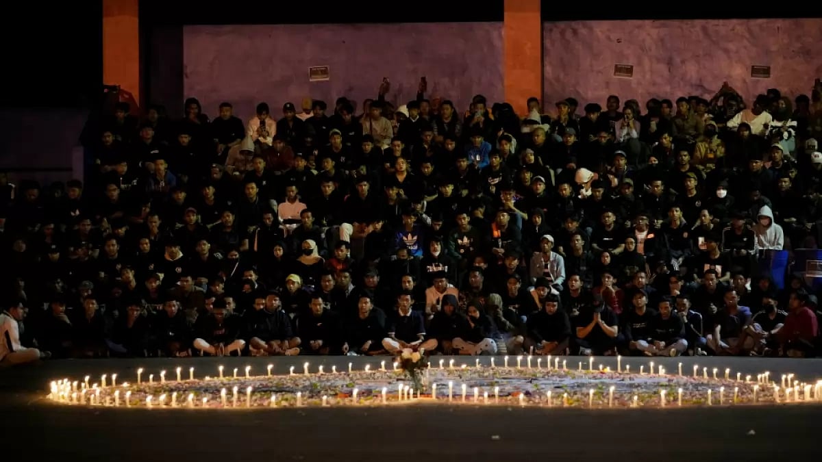 Arema FC fans pray for the victims of Saturday's football match stampede outside the Kanjuruhan Stad