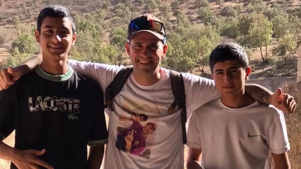 Santiago Sanchez (C) poses with two local boys in Kurdistan on his way to Qatar.  
