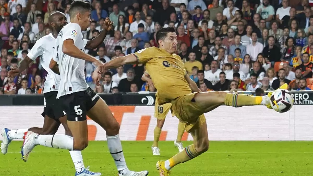 Barcelona's Robert Lewandowski scores against Valencia in La Liga 2022-23.