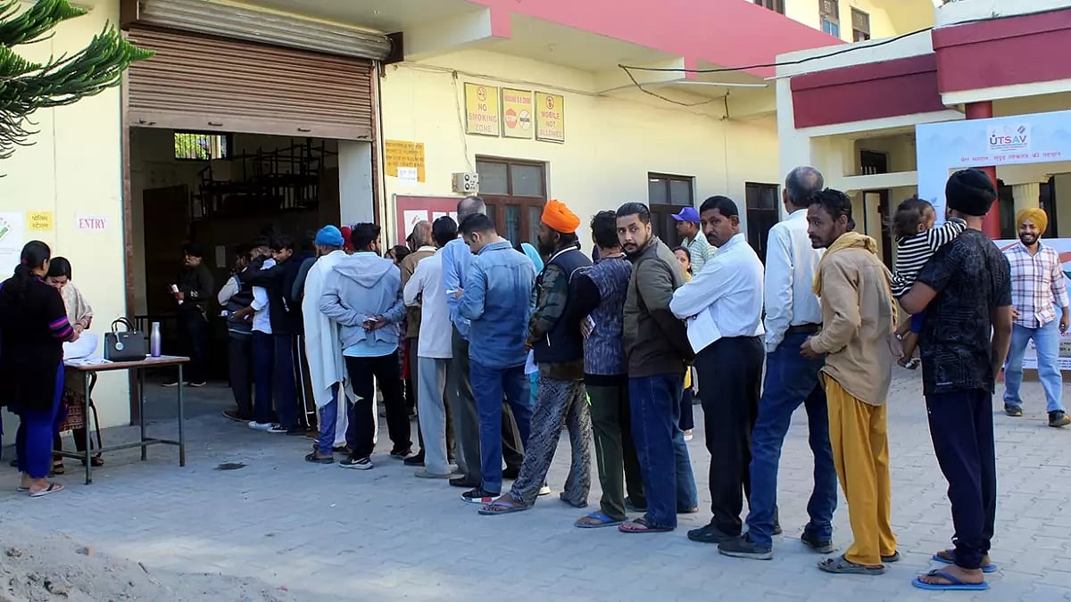 Voters wait in a queue to cast their votes for the Himachal Pradesh Assembly elections