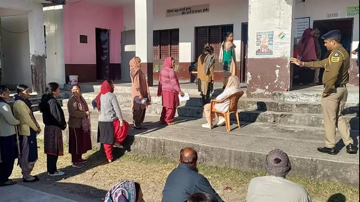 Voters wait in a queue to cast their votes for the Himachal Pradesh Assembly elections, at a polling