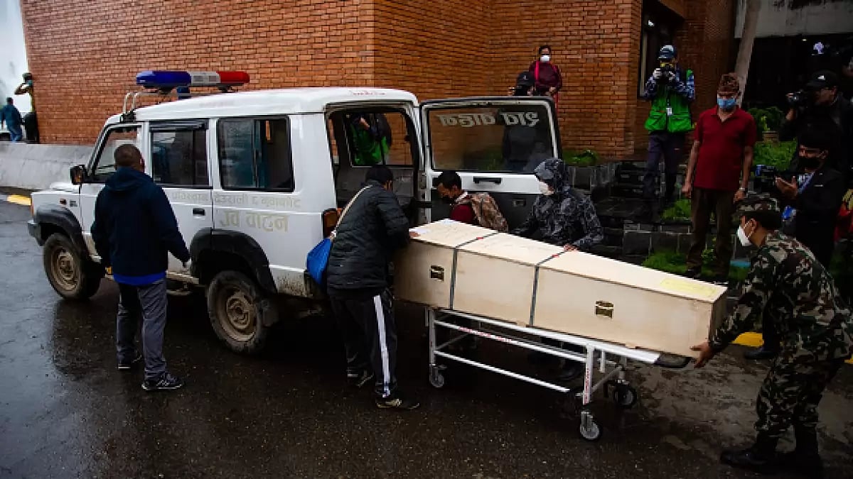 People load a coffin carrying the body of a Nepali migrant worker who died in Qatar 
