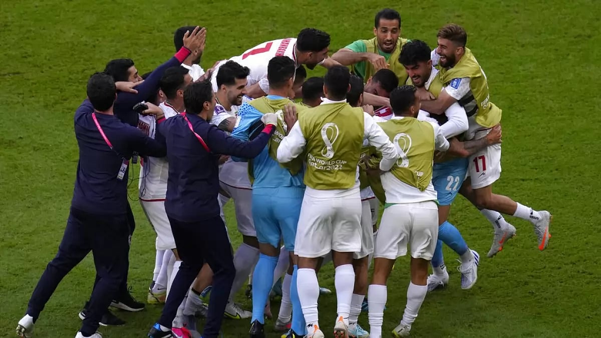 Iran players celebrate their team's first goal against Wales. - File