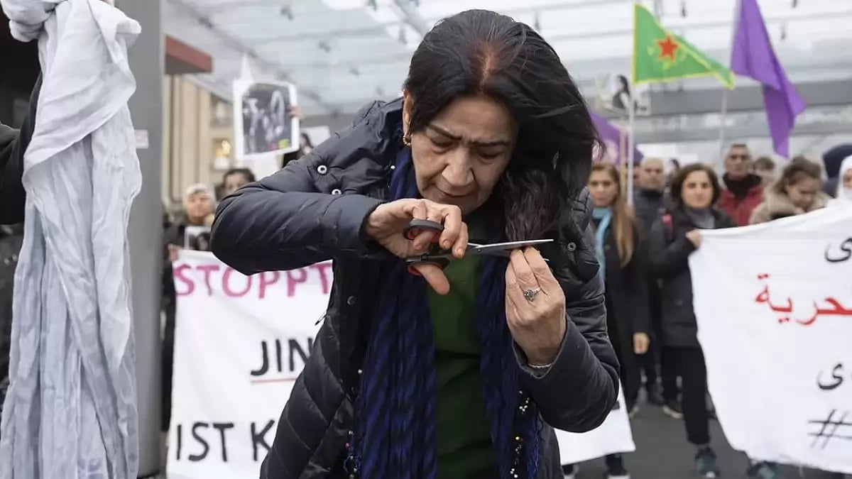 A protester cutting her hair during anti-hijab protests in Iran