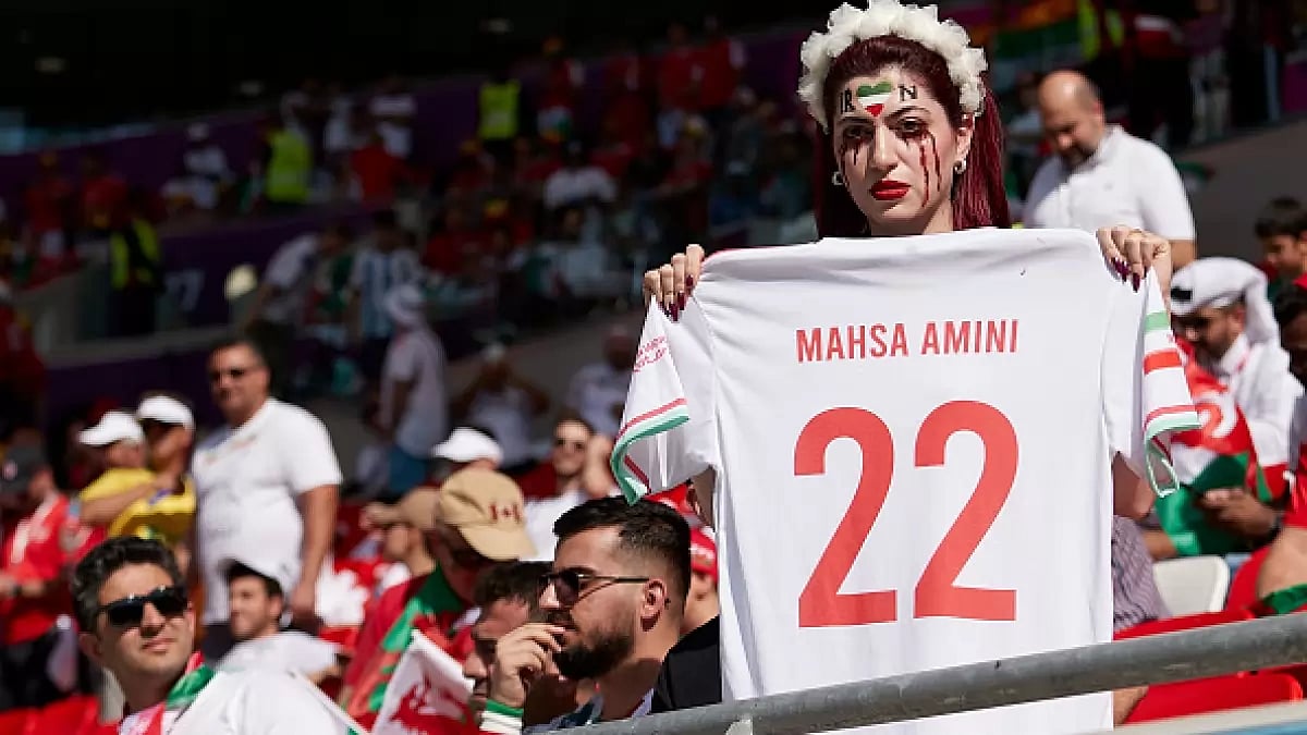 A woman holds a t-shirt protesting the death of Mahsa Amini.