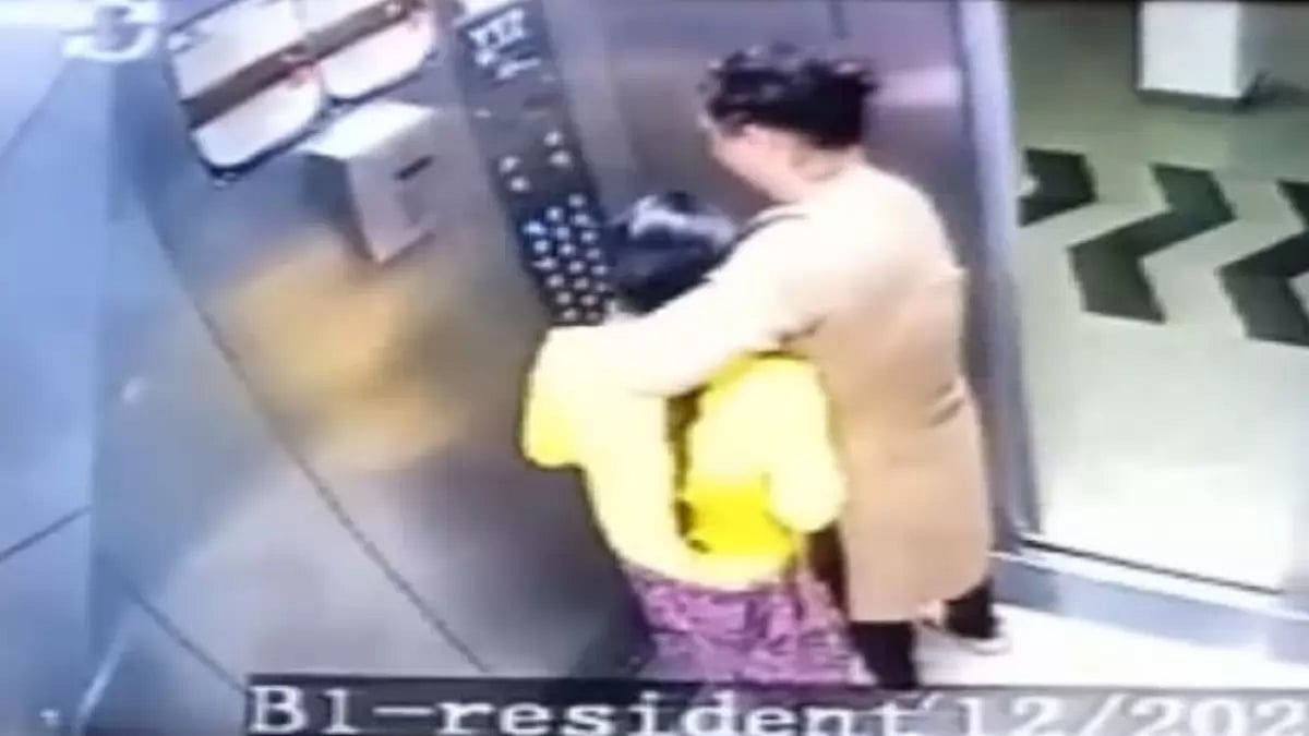Video grab of woman dragging out her domestic help from the lift.