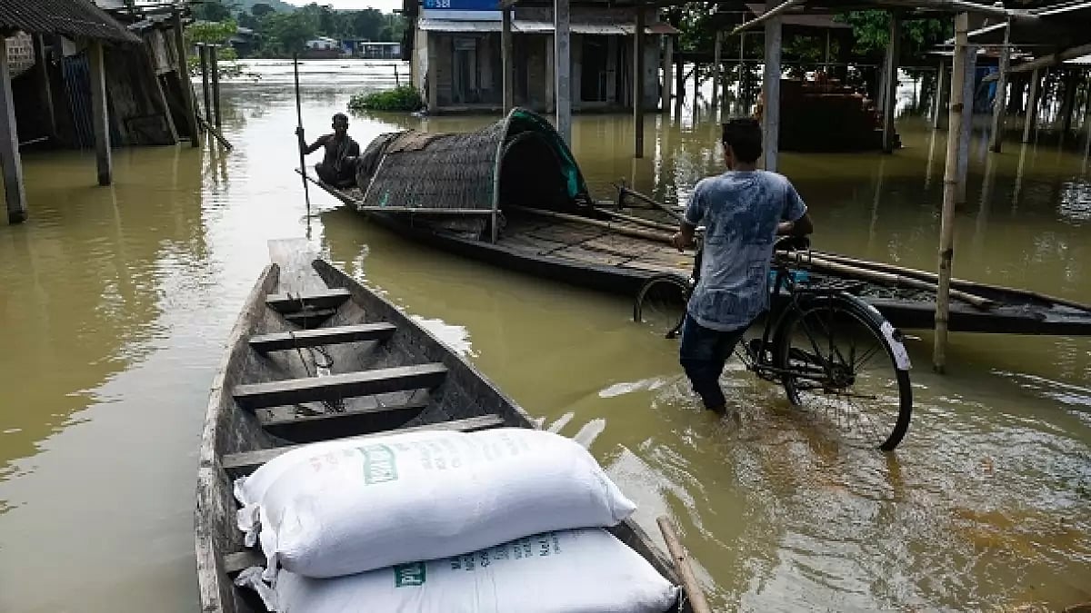 Villager uses a country boat to move across a flooded locality in Morigaon district of Assam. 