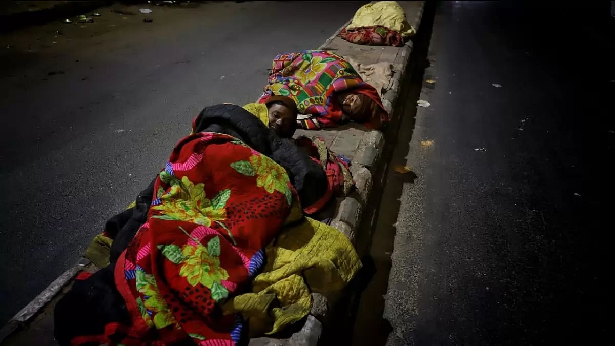 Homeless persons sleeping on footpaths in Delhi on a cold winter night
