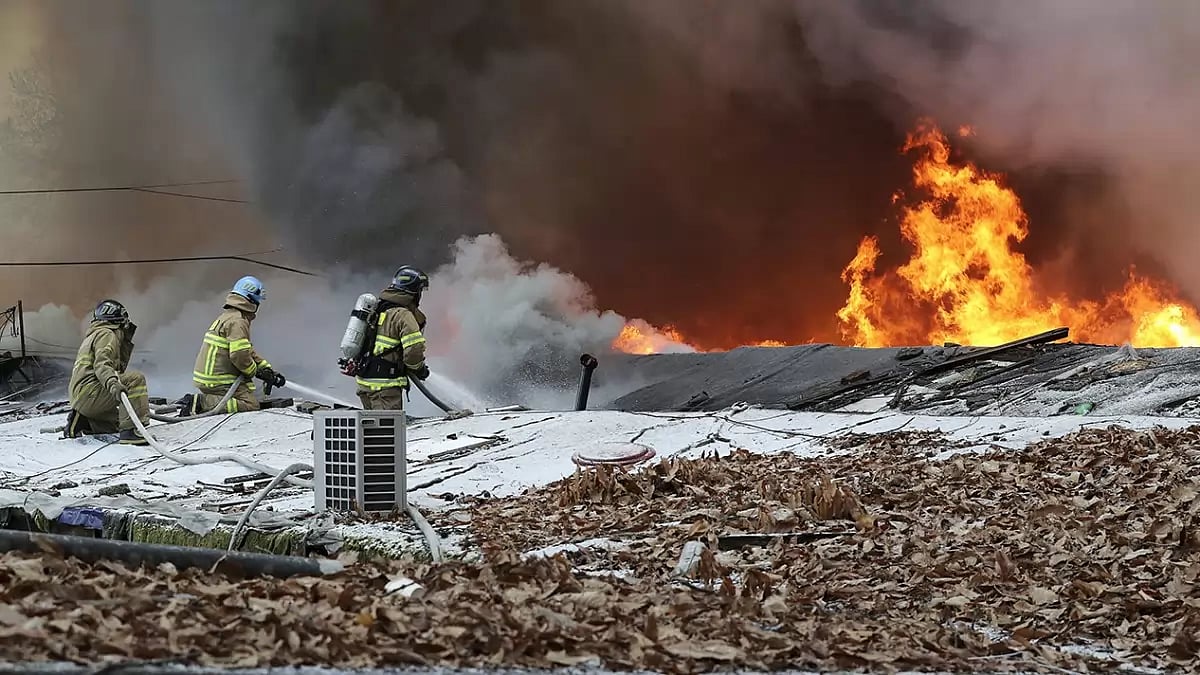 Firefighters clean up the site of a fire