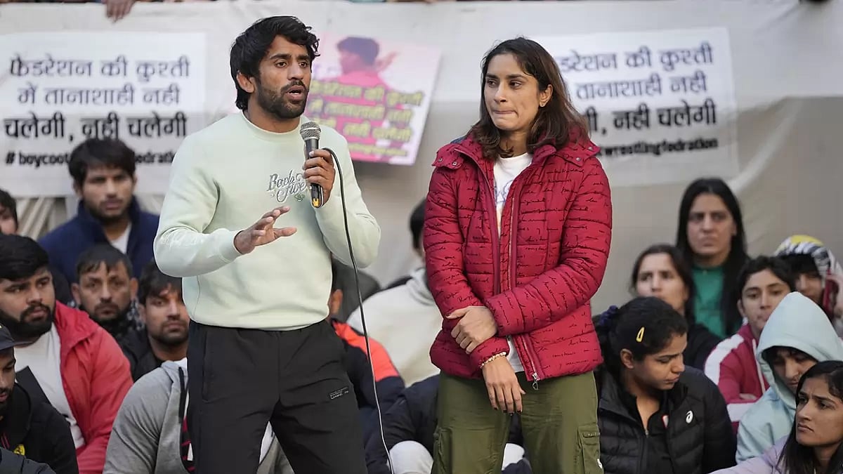 Bajrang Punia speaks as fellow wrestler Vinesh Phogat looks on during their protest against WFI.
