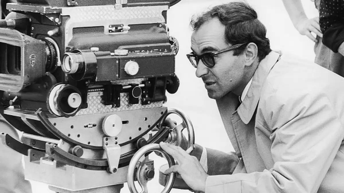 French director Jean-Luc Godard looks through a Chevereau camera during the shooting of the film 