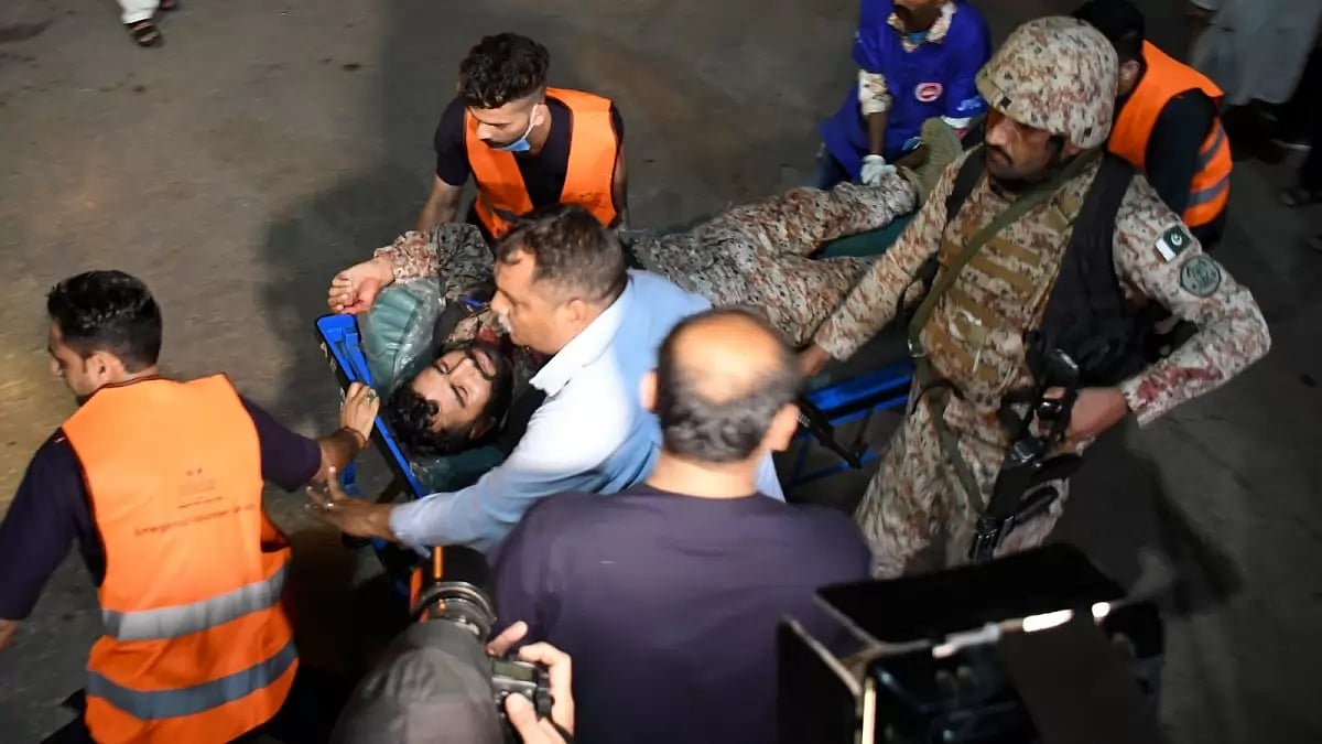 Volunteers and workers carry an injured paramilitary soldier upon arrival at a hospital for treatment, in Karachi, Pakistan,Friday, Feb. 17, 2023.