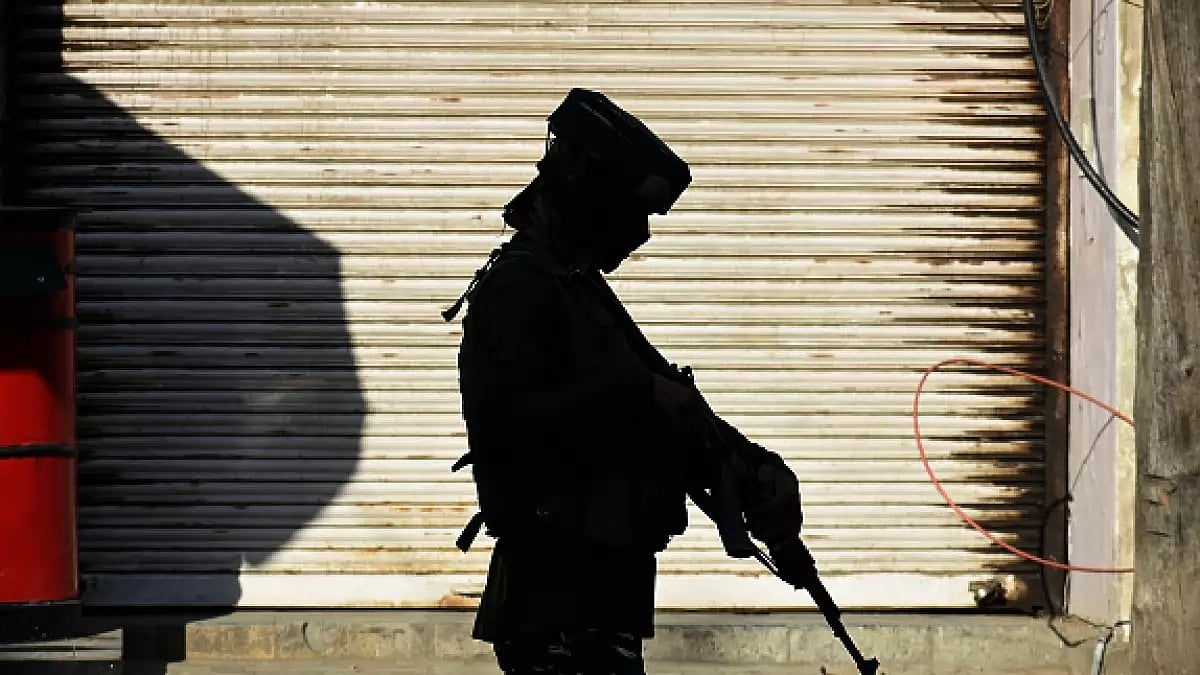 An Indian paramilitary soldier patrols at a busy market in Srinagar, Kashmir
