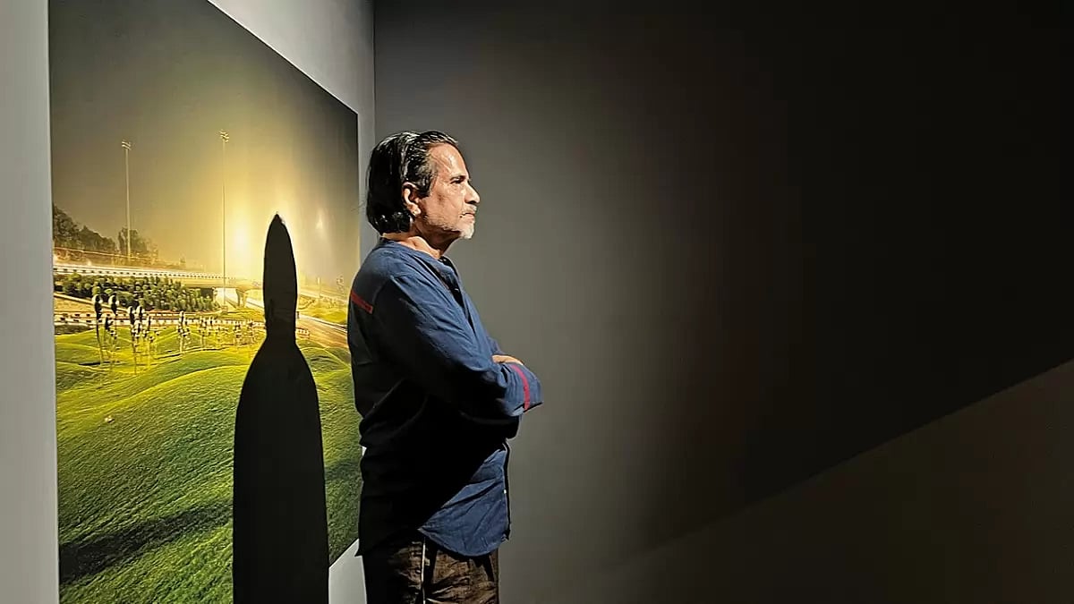 The Fourth State: Sudarshan Shetty standing in front of Sleepers, a photograph by Dhruv Malhotra at the Serendipity Arts Festival  2022, Goa