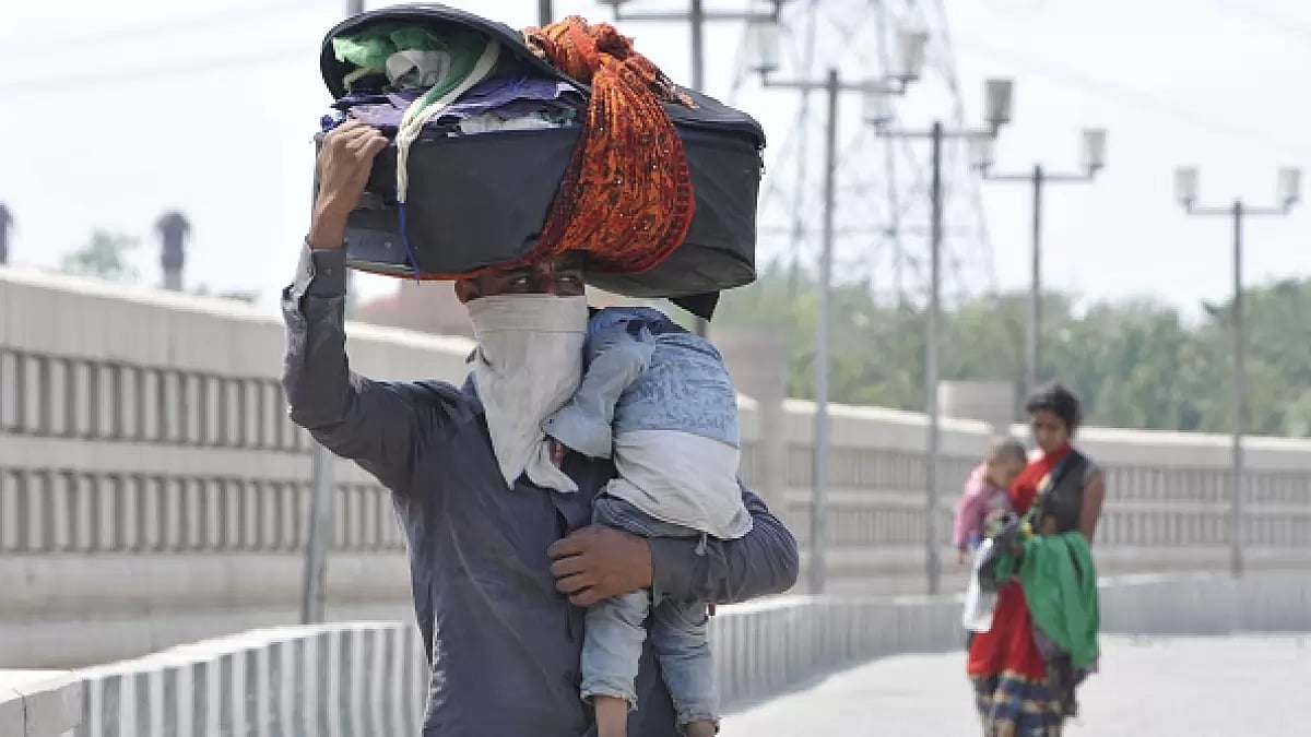  A migrant man and woman, both with children and luggage, walk back from Noida to their native place on foot during lockdown, on May 5, 2020 in Noida, India.