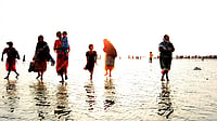 Population Trends: A Progressive Shift Women and children walking along the beach with the waves beneath their feet, West Bengal