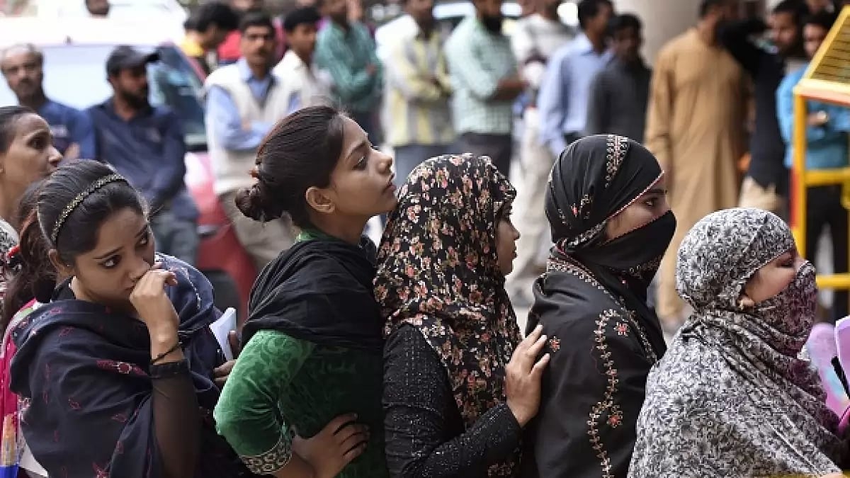 People stand in a queue outside banks to deposit and exchange old denomination Indian rupee 500 and 1,000 currency notes