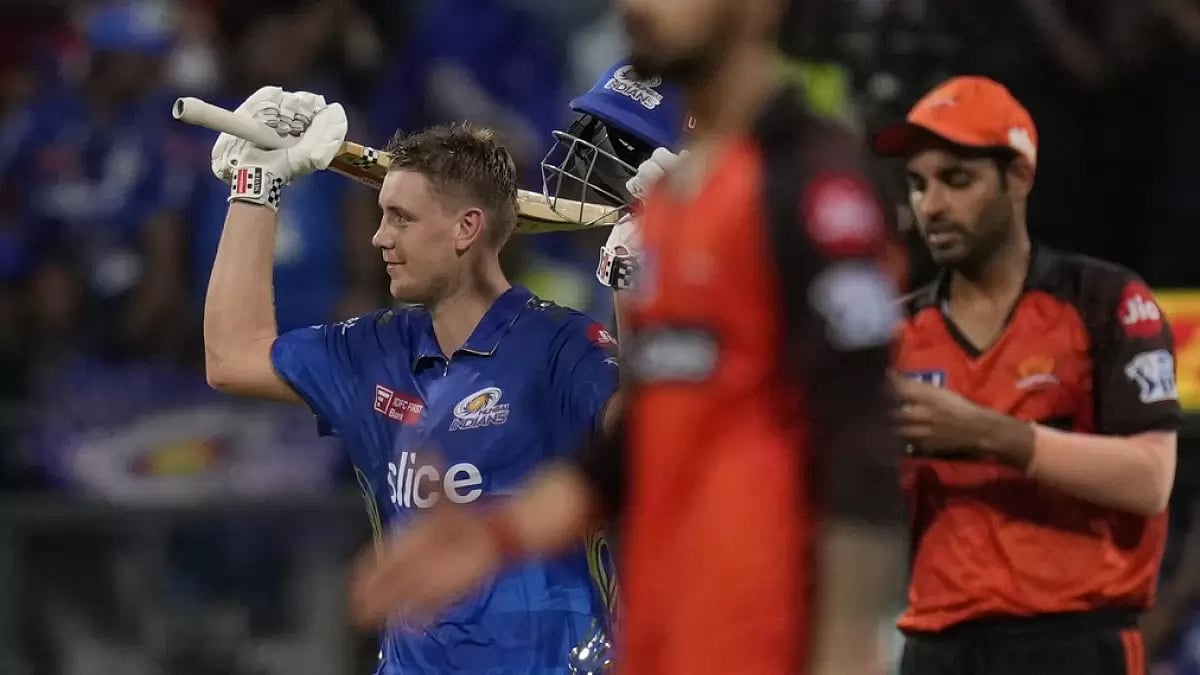 Cameron Green raises his bat after reaching his maiden T20 hundred in Mumbai on Sunday.